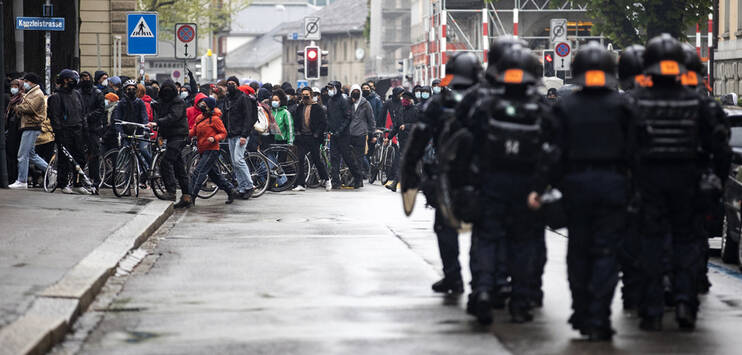 Polizisten stehen vor Demonstranten bei einer Demonstration zum Tag der Arbeit am Samstag im Zentrum von Zürich. (Bild: KEYSTONE/Alexandra Wey)
