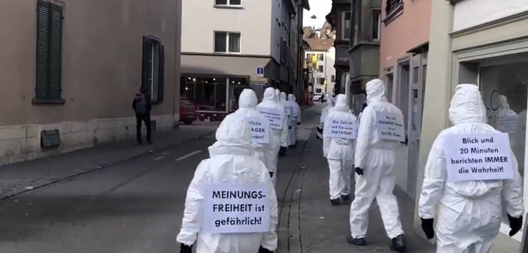 Die Demonstranten zogen in weissen Schutzanzügen durch Schaffhausen. (Bild: Facebook-Video/ProtestMedia)